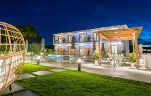 a villa with a swimming pool at night at White Canvas Boutique Studios in Laganas