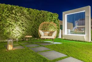 a wicker chair sitting in the middle of a yard at White Canvas Boutique Studios in Laganas +64 photos