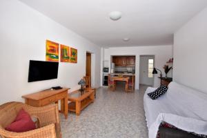 ein Wohnzimmer mit Sofa und Fernseher in der Unterkunft MarySol 2 Apartment with terrace close to the sea in Punta de Mujeres
