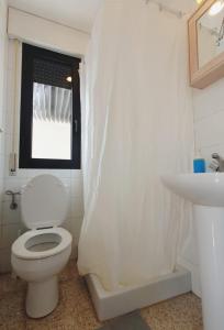 a white bathroom with a toilet and a sink at alquilaencanarias El Medano Spectacular terrace and sea views A in El Médano