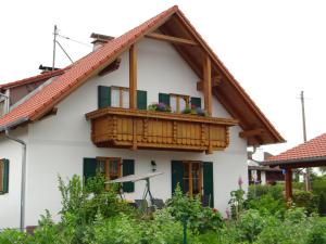 una casa con un balcone fiorito di Fewo zwischen München und Garmisch a Wielenbach