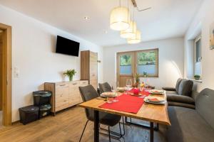 a dining room and living room with a table and chairs at Appartment Dorfblick in Wildschönau