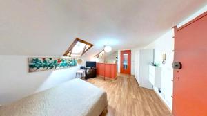 a bedroom with a white bed and a red door at Mansarda loftorino in Turin
