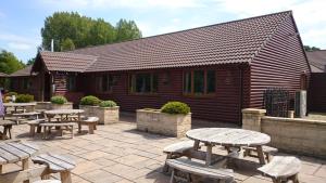 a group of picnic tables in front of a building at Woodland Waters in Ancaster