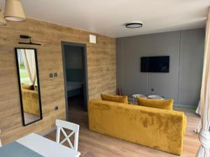 a living room with a yellow couch and a table at Еко Къмпинг Созопол in Sozopol