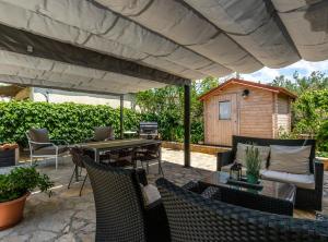 a patio with a table and chairs under an umbrella at Holiday Home Regina in Brodarica