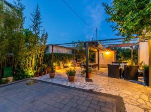 a patio with a table and chairs and plants at Holiday Home Regina in Brodarica
