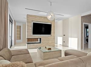 a living room with a couch and a tv on a wall at Villa Freedom in Vodice