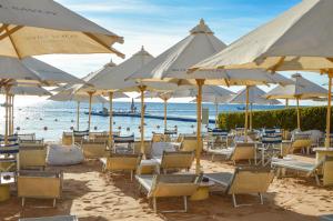 a bunch of chairs and umbrellas on a beach at Royal Savoy Sharm El Sheikh in Sharm El Sheikh