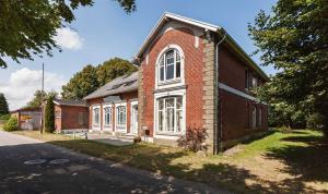 a red brick building with a large window at Ferienwohnung Alter Dorfkrug 4 in Kronsgaard +7 photos