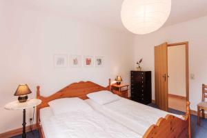 a bedroom with a large white bed with a lamp at Ferienwohnung Alter Dorfkrug 4 in Kronsgaard