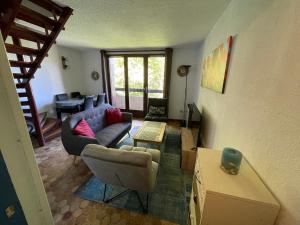 a living room with a couch and a table at Les Chardons - Apt duplex vue montagne in Saint-Léger-les-Mélèzes