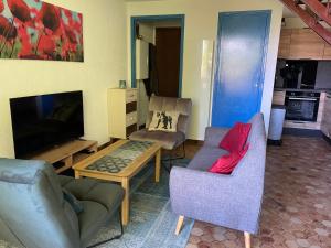 a living room with two chairs and a television at Les Chardons - Apt duplex vue montagne in Saint-Léger-les-Mélèzes +5 photos