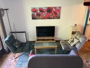 a living room with a couch and a table and chairs at Les Chardons - Apt duplex vue montagne in Saint-Léger-les-Mélèzes