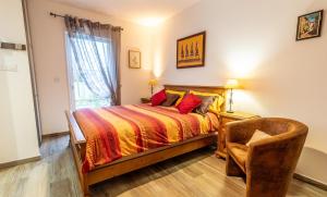 ein Schlafzimmer mit einem Bett und einem Stuhl in der Unterkunft La bourbonnaise in Corme-Royal + 2 Fotos