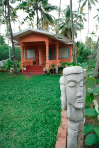 une statue de tête en pierre devant une maison dans l'établissement Temple tree garden beach, à Varkala