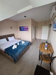 a bedroom with a large bed and a table at Autohof Rekado in Tîrgu Frumos +9 photos