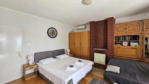 a bedroom with a bed and a clock on the wall at Apartmani Drašnice 1 in Drasnice