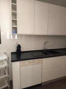Una cocina con gabinetes blancos y un fregadero. en Vilamoura Fantástica Moradia com Piscina Privada, en Vilamoura