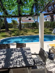 Una mesa y sillas junto a una piscina. en Vilamoura Fantástica Moradia com Piscina Privada, en Vilamoura