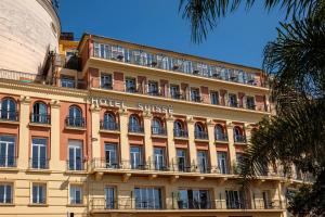 a large building with a hotel sunset on it at Hotel Suisse in Nice