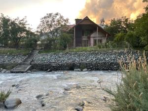 a house on a hill next to a river at Birdsong 6BR Stay with Riverside by Homeyhuts in Pahalgām