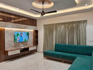 a living room with a couch and a tv at Navishka'S Villa in Panchgani