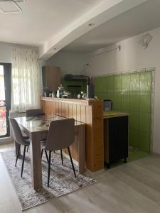 eine Küche mit Tisch und Stühlen in einem Zimmer in der Unterkunft Căsuța Verde in 2 Mai