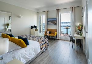 a hotel room with a bed and a desk and a window at Hotel Suisse in Nice
