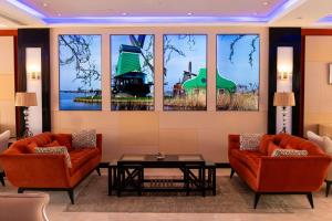 a living room with two chairs and a table and windows at Royal Savoy Sharm El Sheikh in Sharm El Sheikh