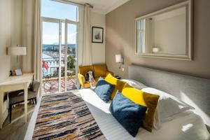 a bedroom with a bed and a desk and a window at Hotel Suisse in Nice
