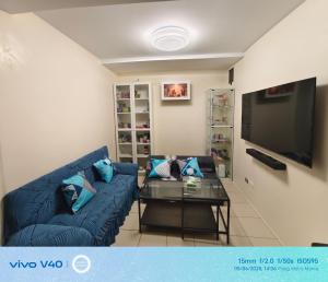 ein Wohnzimmer mit einem blauen Sofa und einem Tisch in der Unterkunft FamBnb in Manila