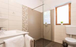 a bathroom with a toilet sink and a shower at Apartments Frgacic in Baška