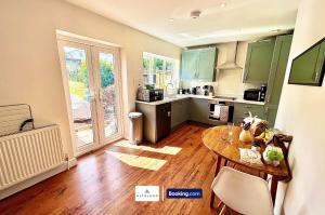 a kitchen with a table in the middle of a room at The Jungle Comfy & Spacious 3BR by AltoLuxo Short Lets & Serviced Accommodation With Free WiFi & Parking in Bristol