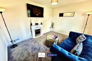 a living room with a blue couch and a fireplace at The Jungle Comfy & Spacious 3BR by AltoLuxo Short Lets & Serviced Accommodation With Free WiFi & Parking in Bristol