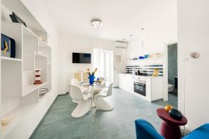 una cocina blanca con mesa y sillas en una habitación en AlMarè Home, en Torre Canne