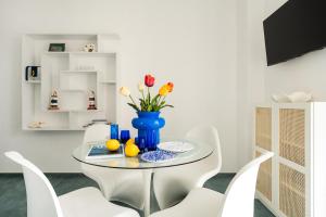 Un comedor con una mesa con un jarrón azul con flores. en AlMarè Home, en Torre Canne