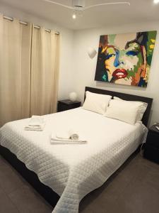 Un dormitorio con una gran cama blanca con un cuadro en la pared. en Vilamoura Fantástica Moradia com Piscina Privada, en Vilamoura 33 fotos más
