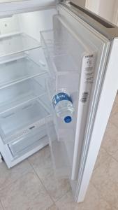 a bottle of water sitting inside of an open refrigerator at BougainvillaStudio in Cesme