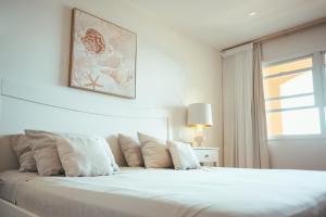 a white bed in a bedroom with a window at Beach House The Strand in Willemstad