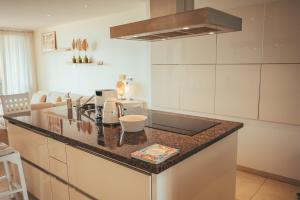 a kitchen with a counter top in a room at Beach House The Strand in Willemstad +24 photos