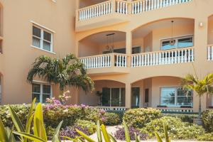 a building with a balcony and flowers in front of it at Beach House The Strand in Willemstad