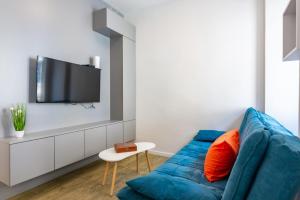 a living room with a blue couch and a tv at B&B apartment 2 in Rijeka +3 photos