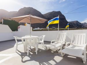stół, krzesła i parasol na dachu w obiekcie Apartamento Minimalista con Terraza, WiFi y a 1 Minuto de la Playa - ES-279-4 w mieście Garachico