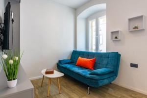 a blue couch with an orange pillow in a living room at B&B apartment 2 in Rijeka