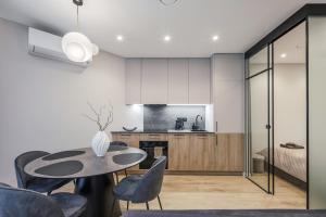 a kitchen and dining room with a table and chairs at Sea Whisper apartamentai Daukanto g Palanga in Palanga