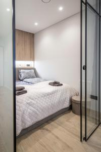 a bedroom with a bed and a glass wall at Sea Whisper apartamentai Daukanto g Palanga in Palanga
