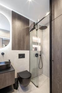 a bathroom with a shower with a toilet and a sink at Sea Whisper apartamentai Daukanto g Palanga in Palanga +8 photos