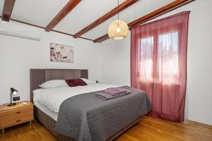 a bedroom with a bed and a large window at House Trget in Trget