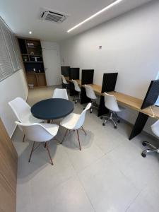 a conference room with tables and white chairs at Westfit Barreto 03 in Mossoró +9 photos